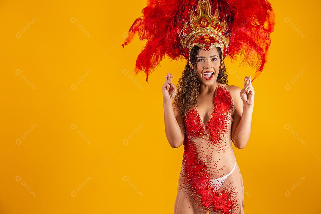 Retrato de mulher afro brasileira com roupa de carnaval com os dedos cruzados desejando sorte