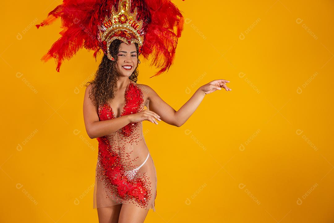 Linda jovem fêmea em traje especial de penas está dançando no estúdio Samba de carnaval