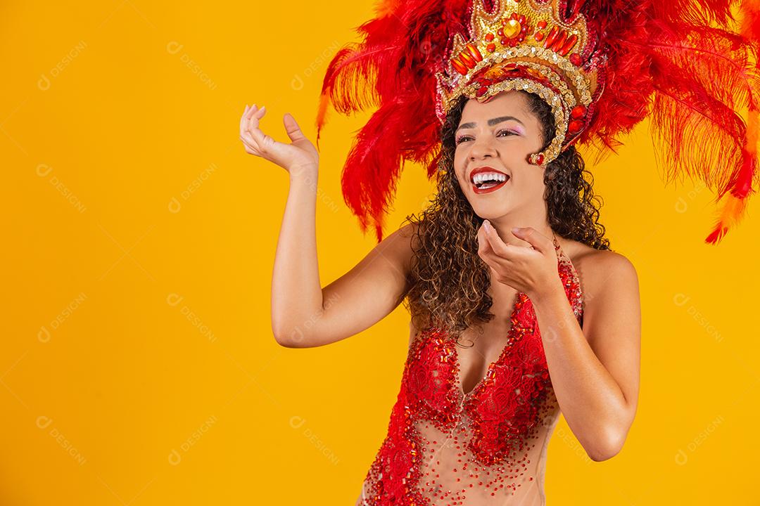 Linda jovem fêmea em traje especial de penas está dançando no estúdio Samba de carnaval