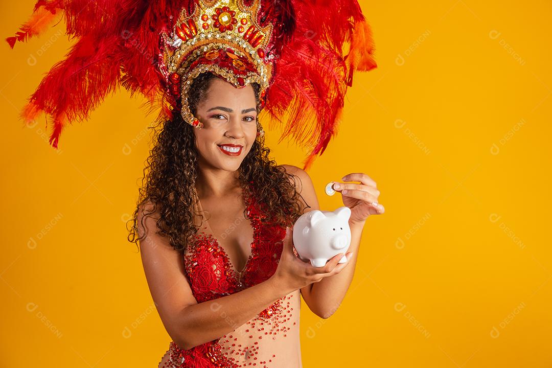 Mulher de dançarina de carnaval segurando um cofrinho nas mãos. Conceito de economia para o carnaval