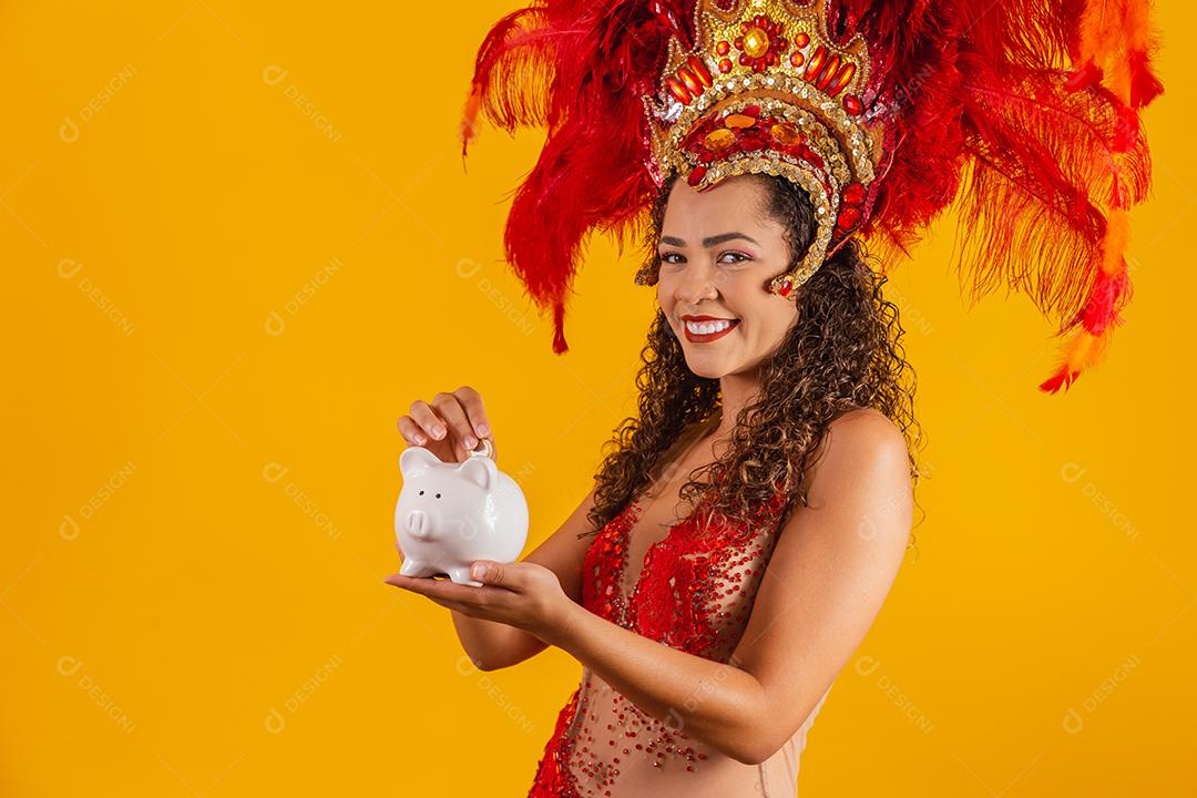 Mulher de dançarina de carnaval segurando um cofrinho nas mãos. Conceito de economia para o carnaval