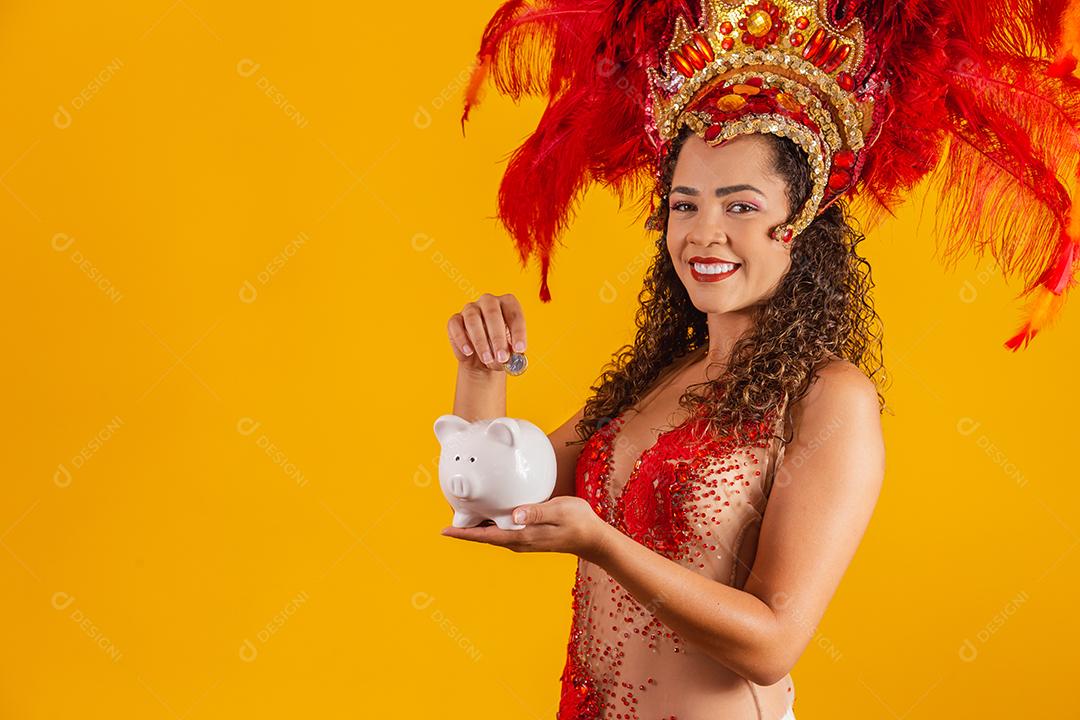 Mulher de dançarina de carnaval segurando um cofrinho nas mãos. Conceito de economia para o carnaval