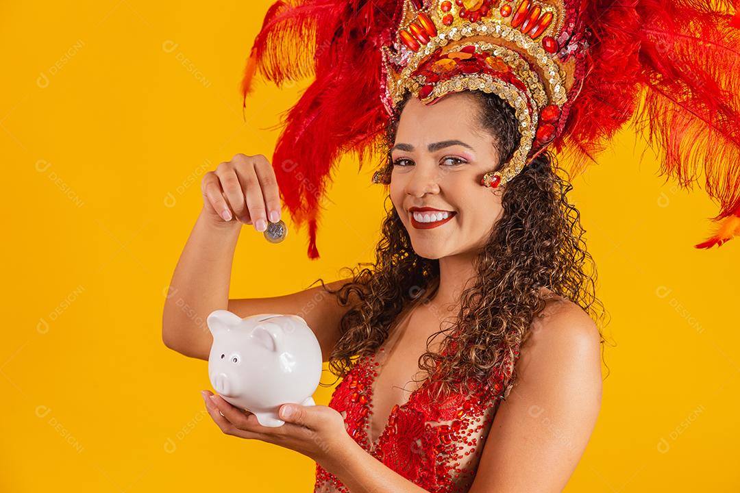 Mulher de dançarina de carnaval segurando um cofrinho nas mãos. Conceito de economia para o carnaval