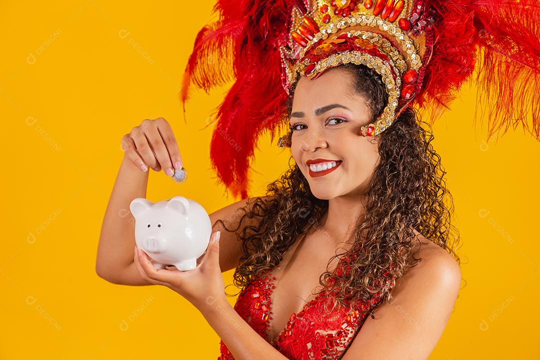 Mulher de dançarina de carnaval segurando um cofrinho nas mãos. Conceito de economia para o carnaval