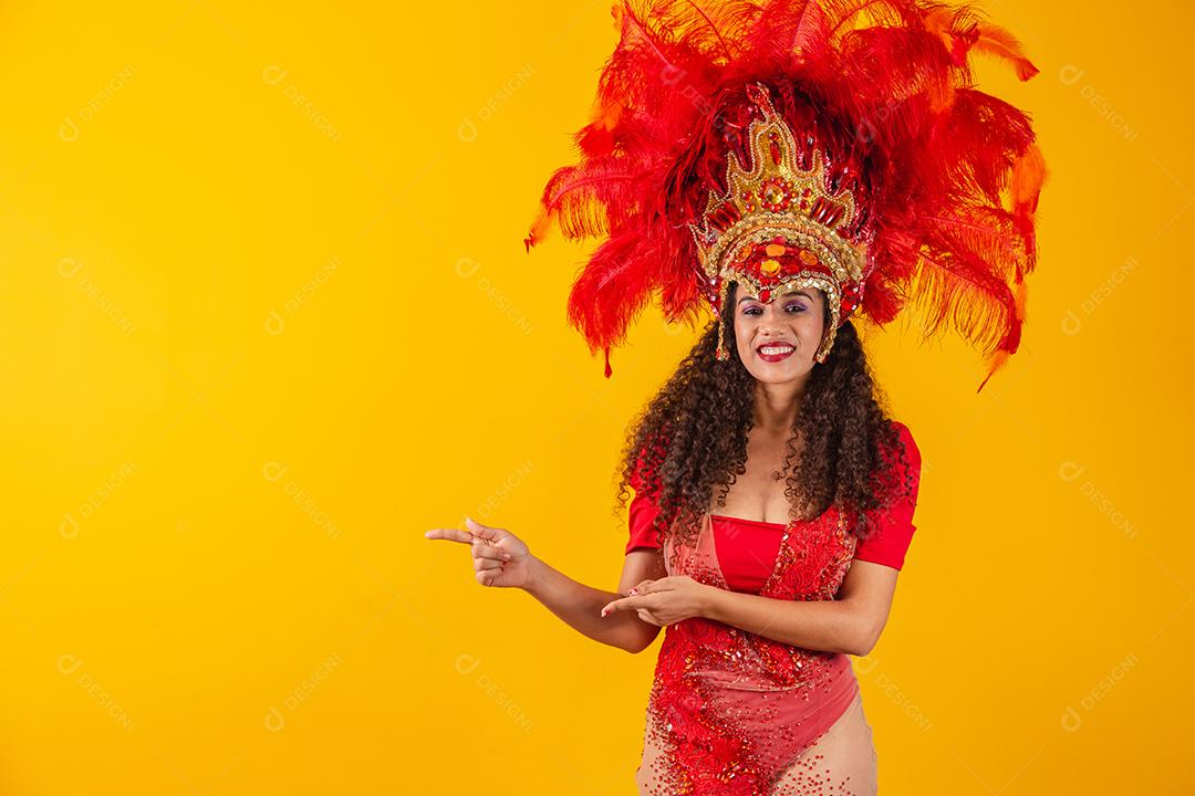 Mulher dançarina de carnaval apontando para o lado.