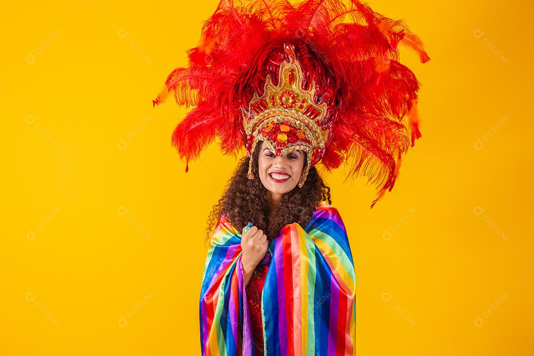 Linda mulher afro com roupa de carnaval de bandeira lgbt em fundo amarelo.