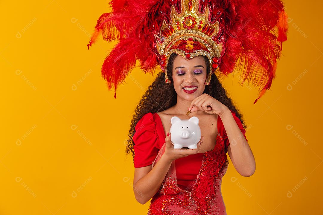 Mulher de dançarina de carnaval segurando um cofrinho nas mãos. Conceito de economia para o carnaval