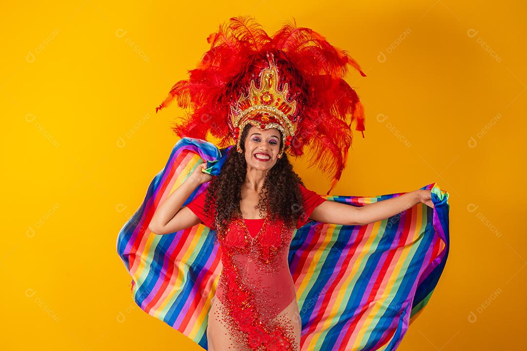 Linda mulher afro com roupa de carnaval de bandeira lgbt em fundo amarelo.