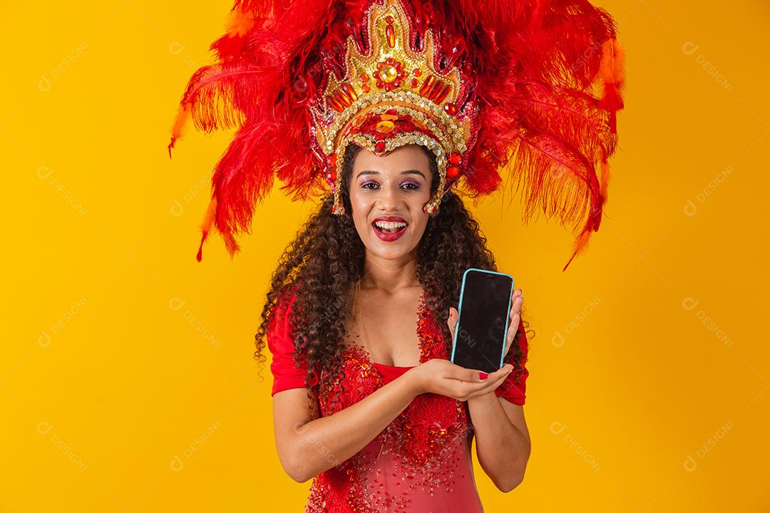 Beautiful young woman in special carnival feather costume holding a smartphone