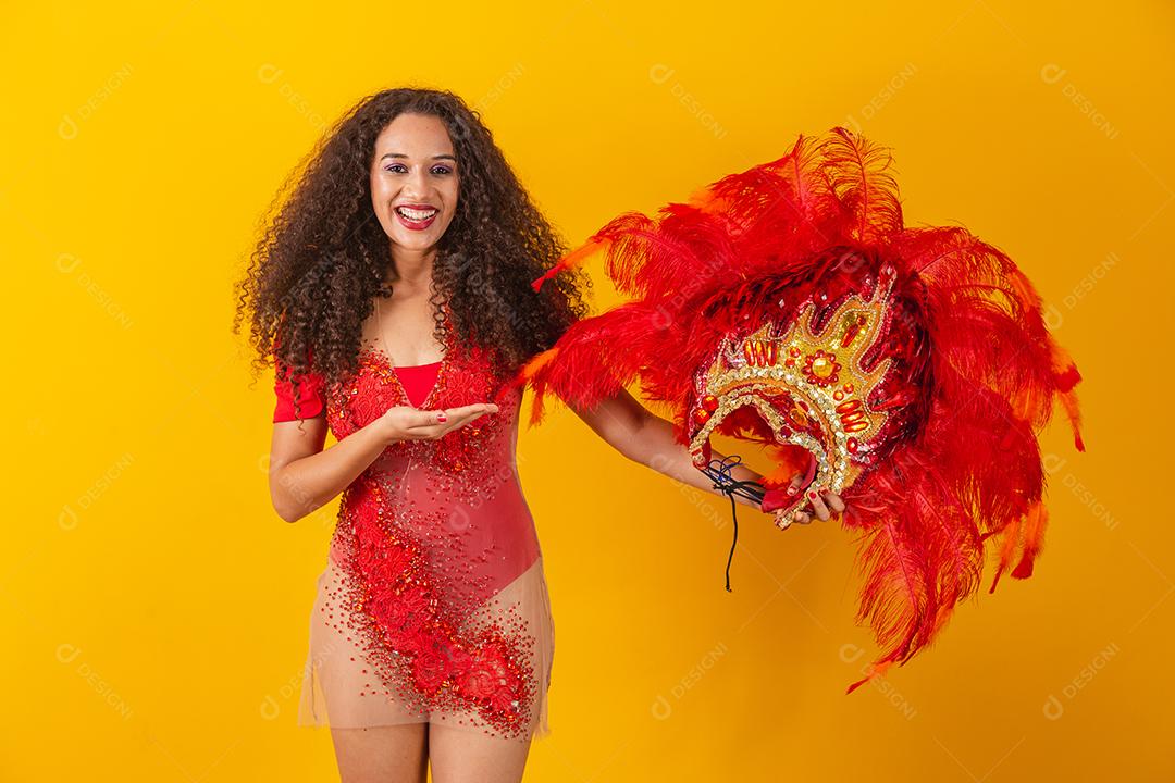 foto de mulher afro vestida para o carnaval com roupa de dançarina segurando sua coroa na mão.