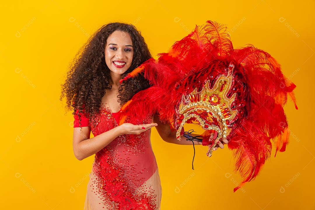 foto de mulher afro vestida para o carnaval com roupa de dançarina segurando sua coroa na mão.