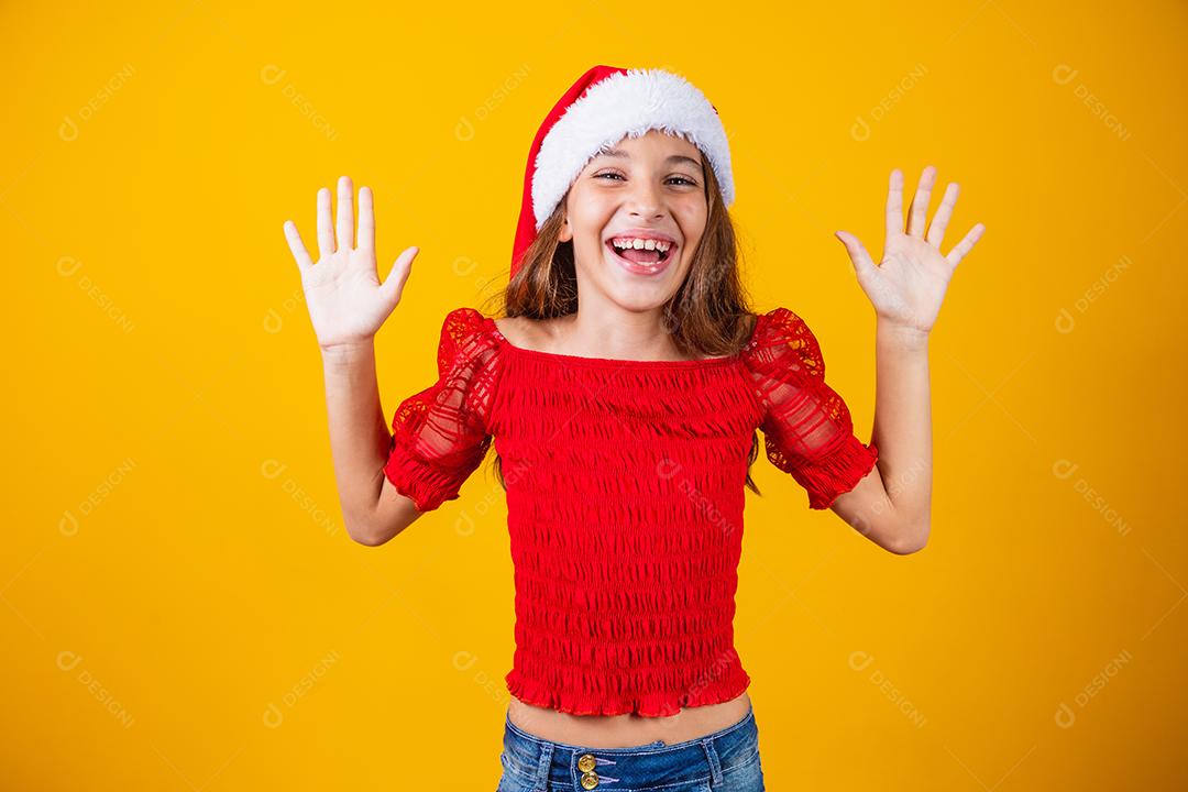 Menina animada para o Natal expressivo em fundo amarelo.