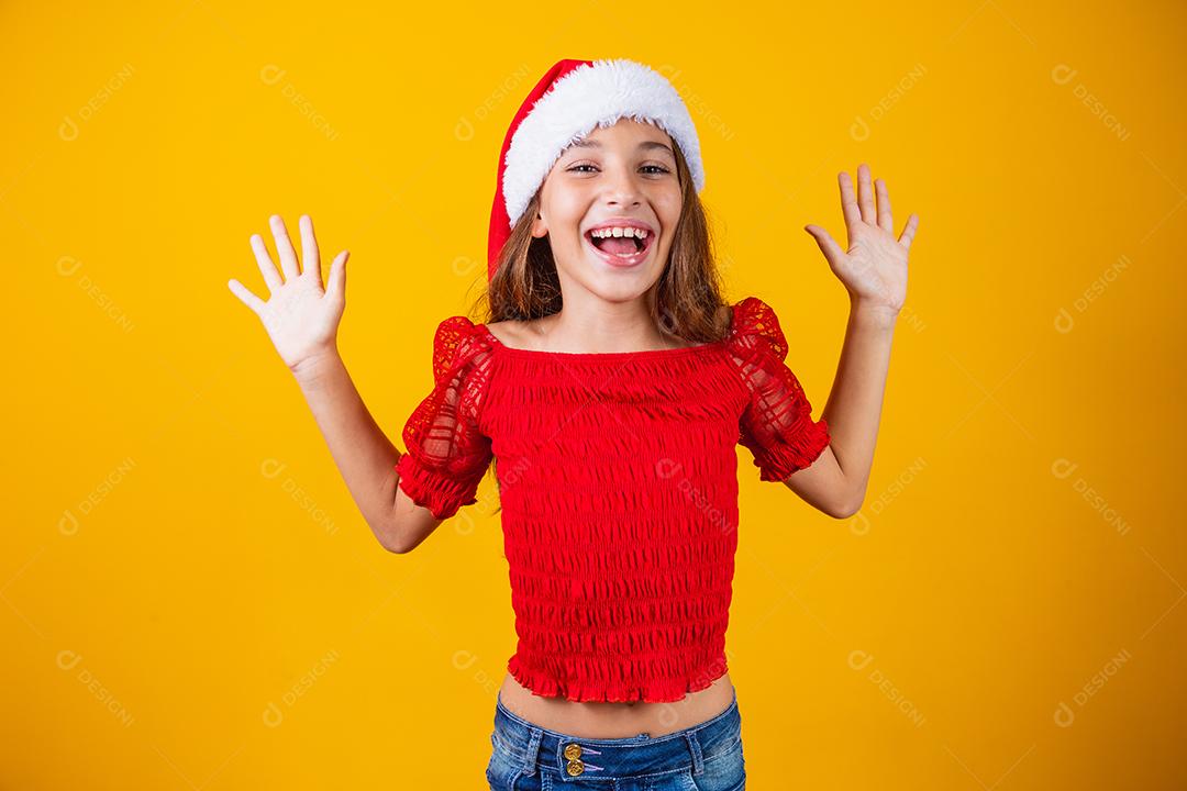 Menina animada para o Natal expressivo em fundo amarelo.