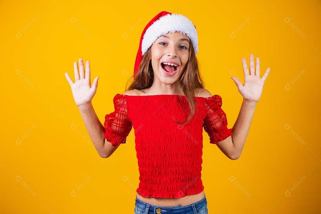 Menina animada para o Natal expressivo em fundo amarelo.