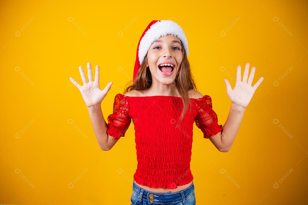 Menina animada para o Natal expressivo em fundo amarelo.