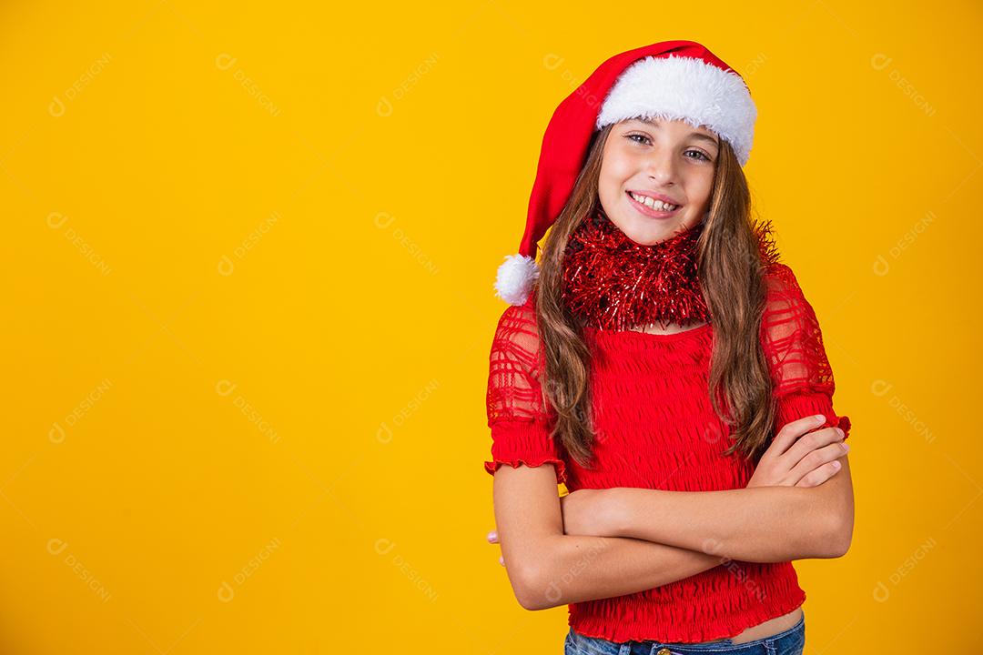 menina sorridente bonitinha com roupa de natal e braços cruzados.