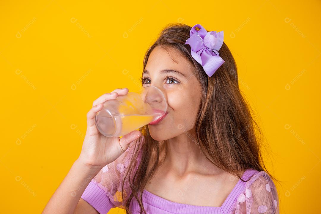 Linda menina saudável bebendo um copo de água.