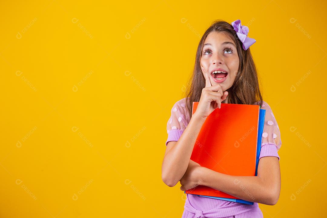 Aluna caucasiana com livros nas mãos e o dedo para cima. de volta à escola