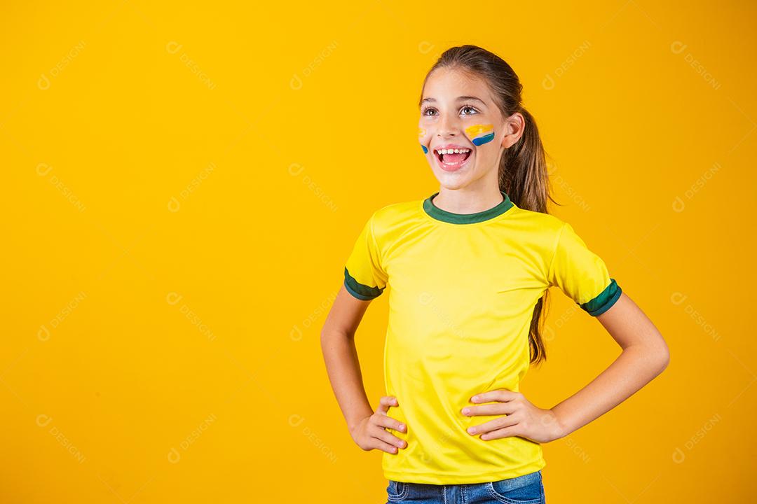 Torcedor de futebol, seleção brasileira. Linda garotinha torcendo por seu time em fundo amarelo