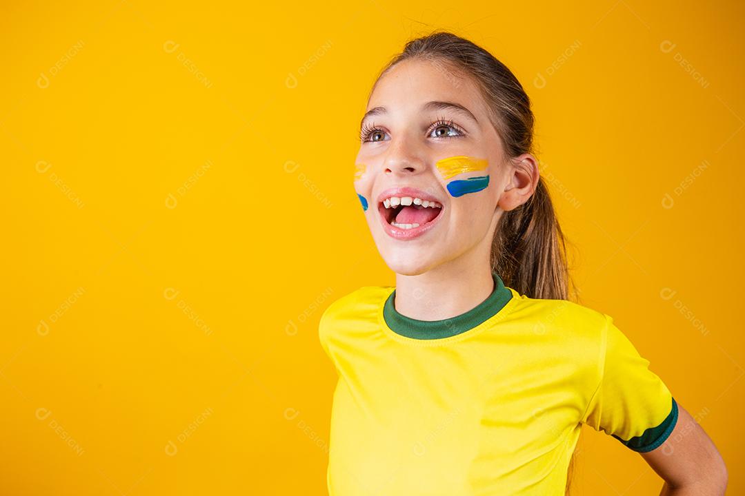 Torcedor de futebol, seleção brasileira. Linda garotinha torcendo por seu time em fundo amarelo