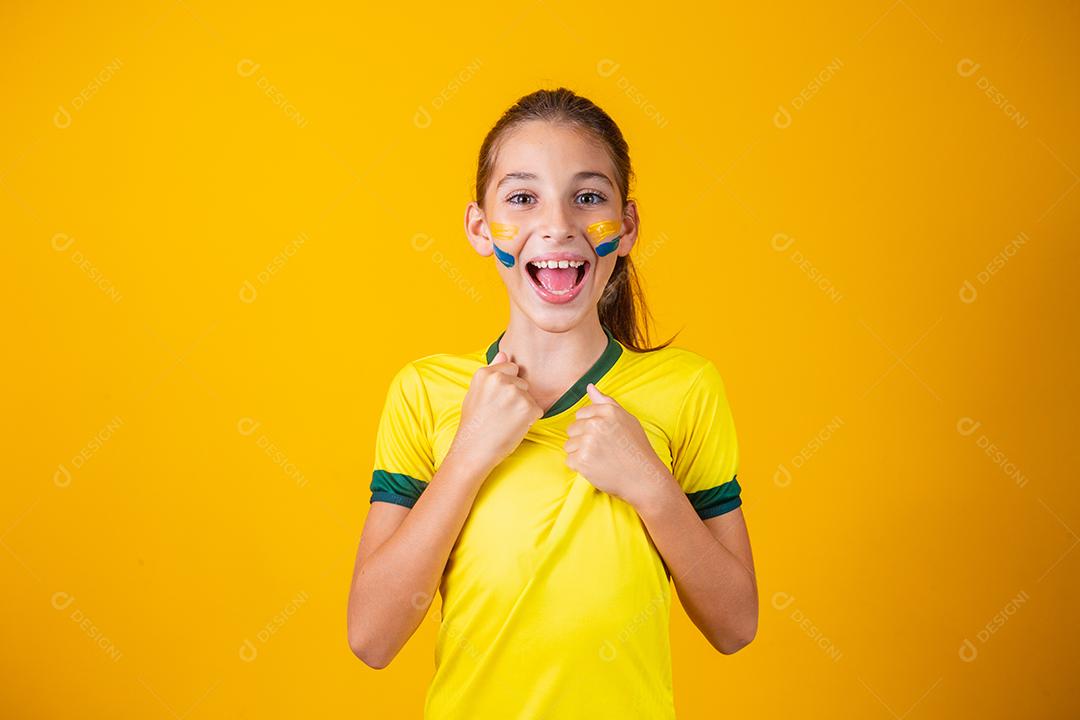 Torcedor de futebol, seleção brasileira. Linda garotinha torcendo por seu time em fundo amarelo