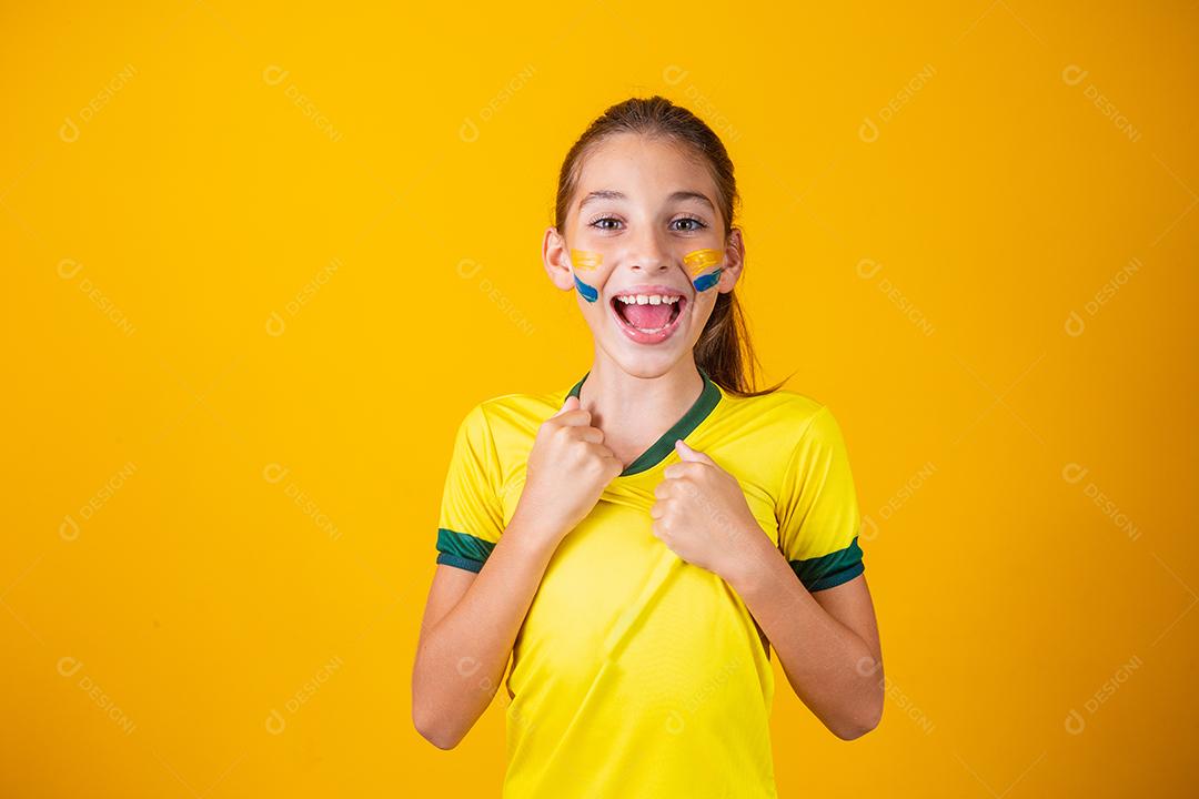 Torcedor de futebol, seleção brasileira. Linda garotinha torcendo por seu time em fundo amarelo