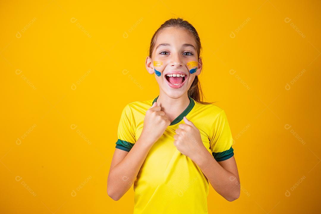 Torcedor de futebol, seleção brasileira. Linda garotinha torcendo por seu time em fundo amarelo