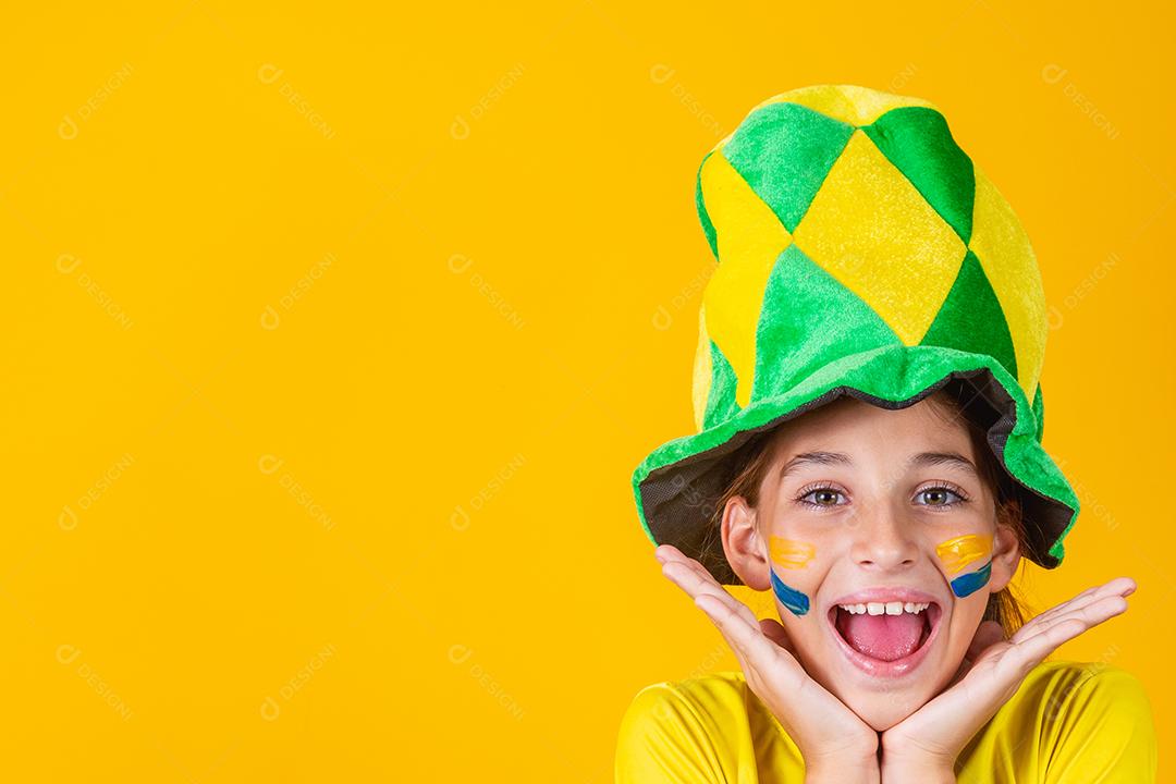 Linda garotinha torcendo por seu time em fundo amarelo. Menina comemorando o gol e comemorando a vitória do Brasil