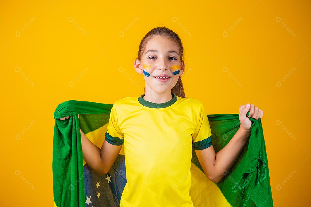 Torcedor de futebol, seleção brasileira. Linda garotinha torcendo por seu time em fundo amarelo
