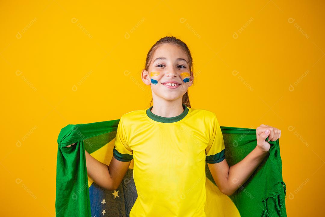 Torcedor de futebol, seleção brasileira. Linda garotinha torcendo por seu time em fundo amarelo