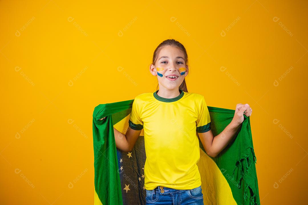 Torcedor de futebol, seleção brasileira. Linda garotinha torcendo por seu time em fundo amarelo