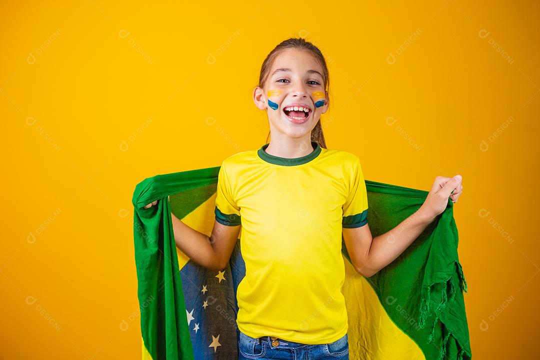 Torcedor de futebol, seleção brasileira. Linda garotinha torcendo por seu time em fundo amarelo