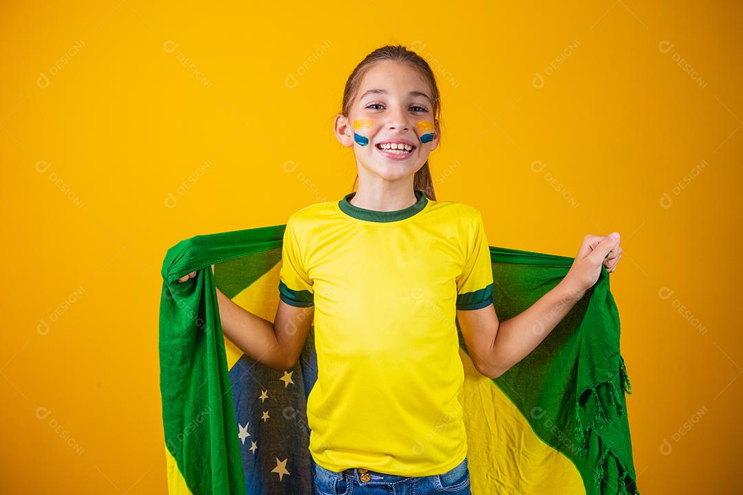 Torcedor de futebol, seleção brasileira. Linda garotinha torcendo por seu time em fundo amarelo