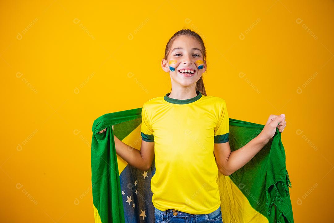 Torcedor de futebol, seleção brasileira. Linda garotinha torcendo por seu time em fundo amarelo