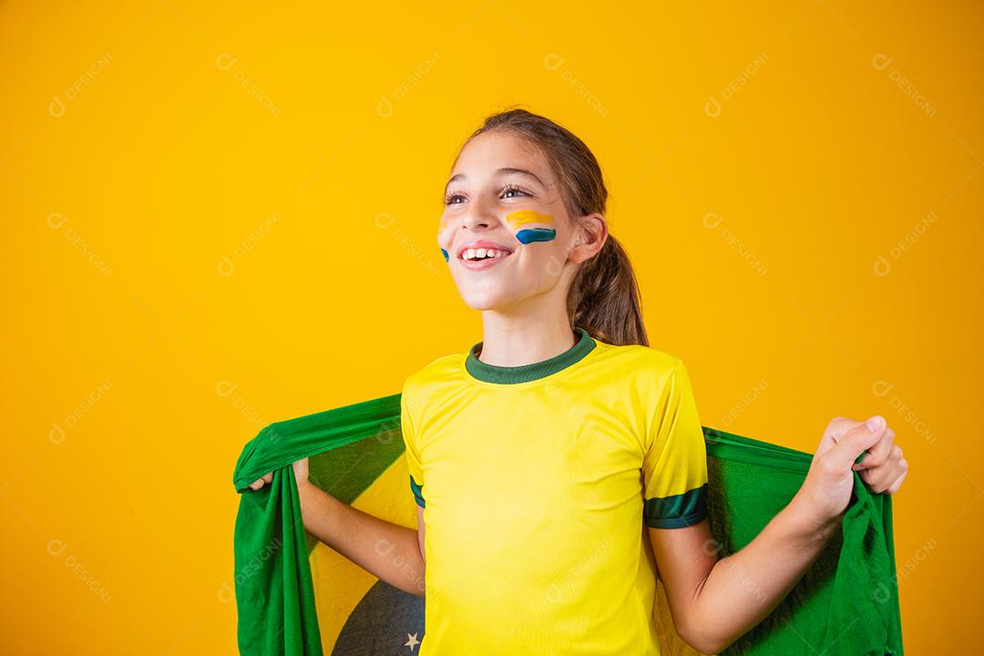 Torcedor de futebol, seleção brasileira. Linda garotinha torcendo por seu time em fundo amarelo