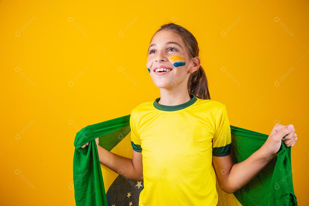 Torcedor de futebol, seleção brasileira. Linda garotinha torcendo por seu time em fundo amarelo