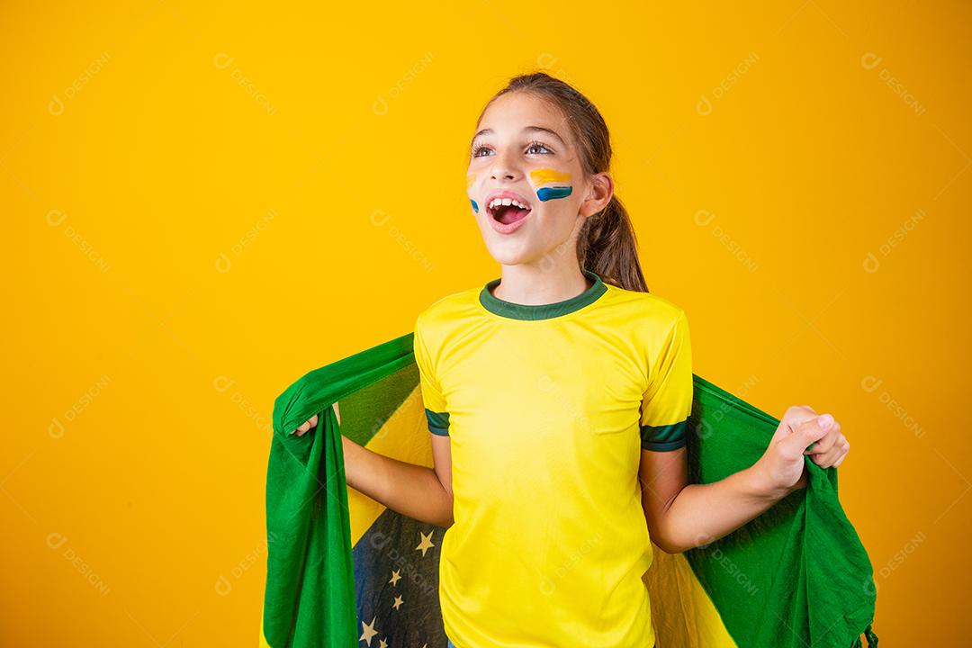 Torcedor de futebol, seleção brasileira. Linda garotinha torcendo por seu time em fundo amarelo