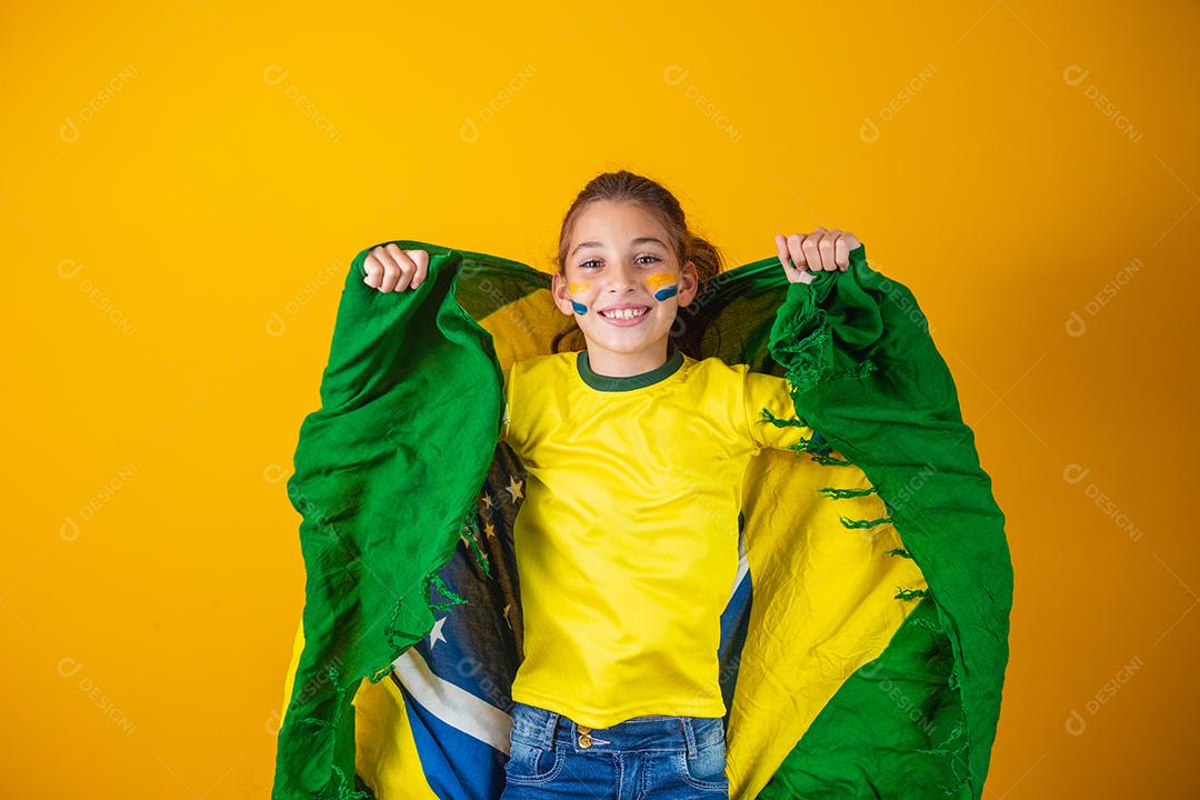 Torcedor de futebol, seleção brasileira. Linda garotinha torcendo por seu time em fundo amarelo