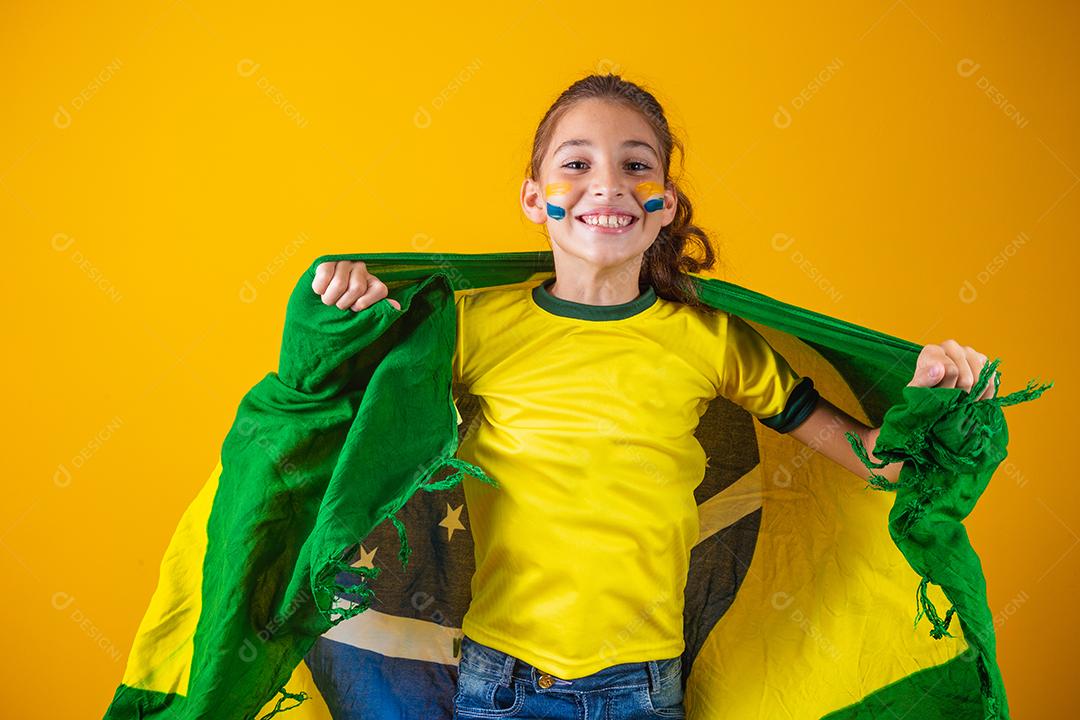 Torcedor de futebol, seleção brasileira. Linda garotinha torcendo por seu time em fundo amarelo