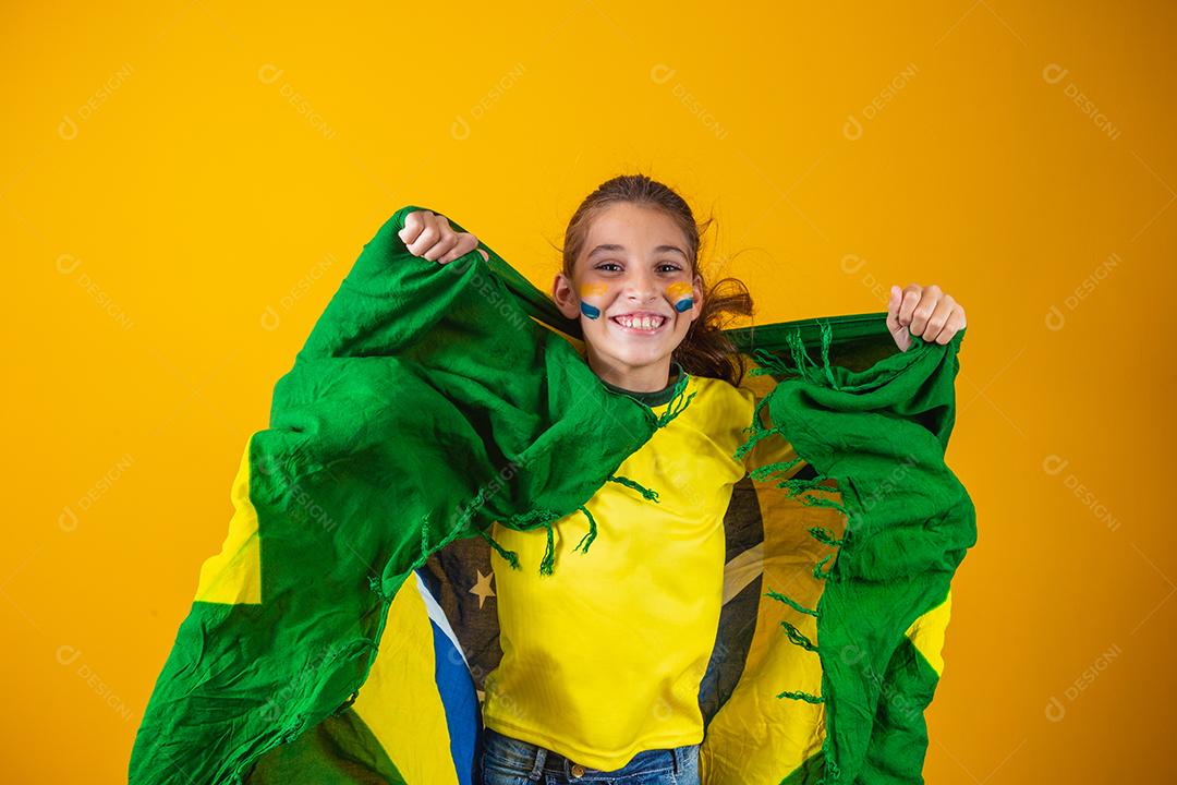 Torcedor de futebol, seleção brasileira. Linda garotinha torcendo por seu time em fundo amarelo
