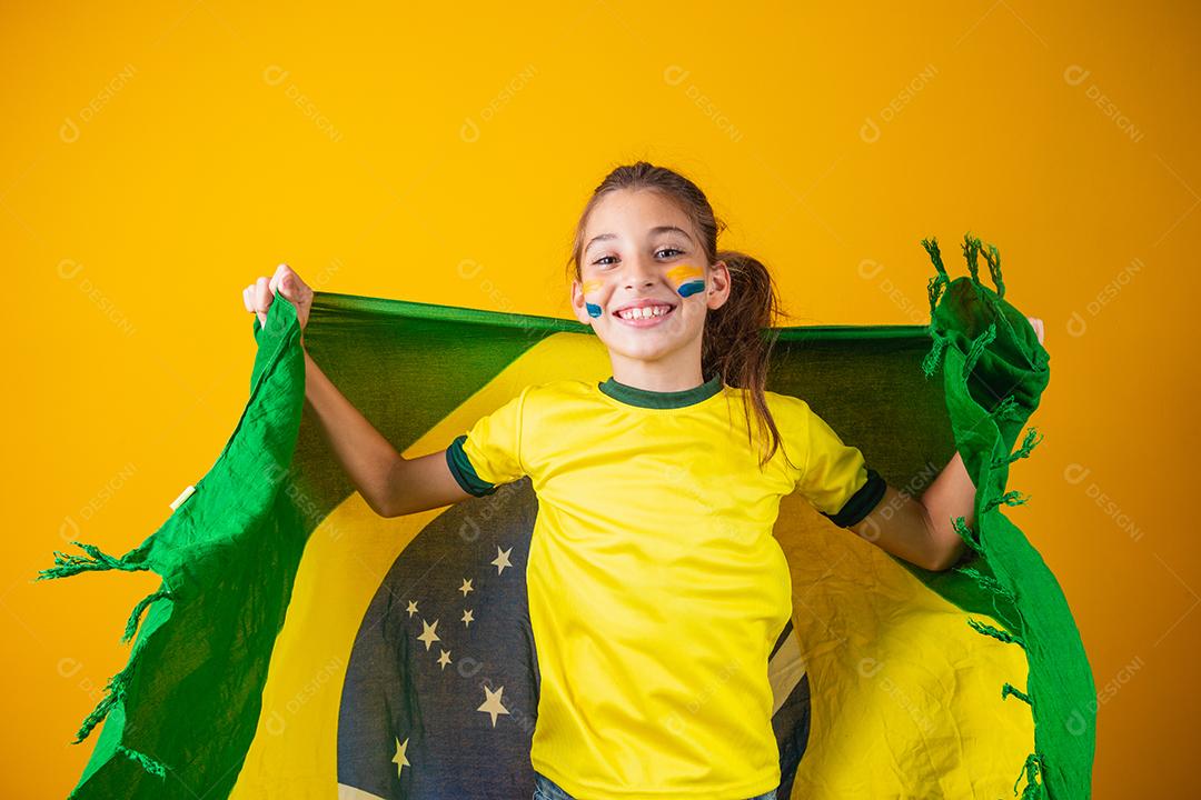 Torcedor de futebol, seleção brasileira. Linda garotinha torcendo por seu time em fundo amarelo