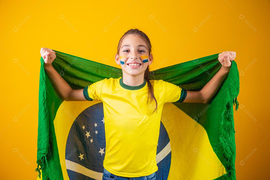 Torcedor de futebol, seleção brasileira. Linda garotinha torcendo por seu time em fundo amarelo