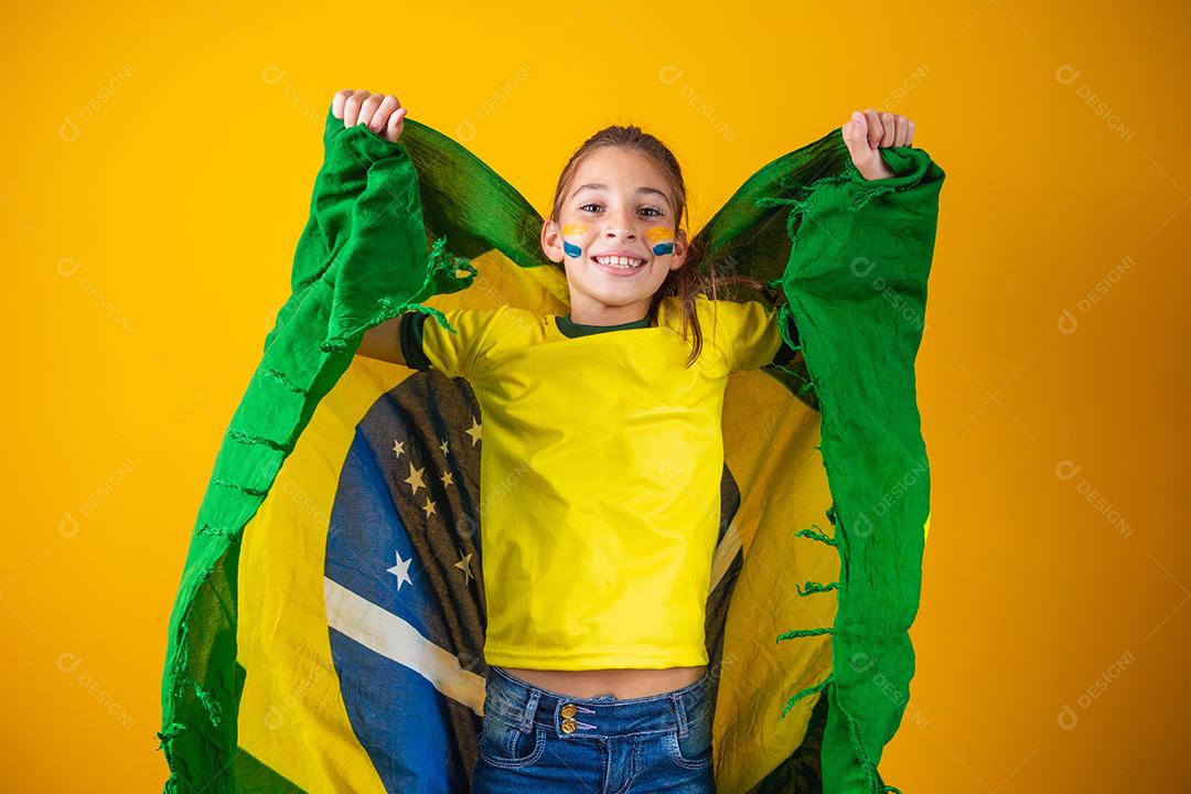 Torcedor de futebol, seleção brasileira. Linda garotinha torcendo por seu time em fundo amarelo