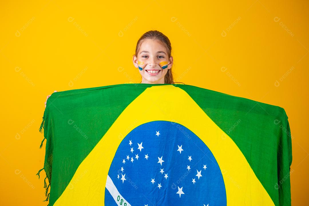 Torcedor de futebol, seleção brasileira. Linda garotinha torcendo por seu time em fundo amarelo
