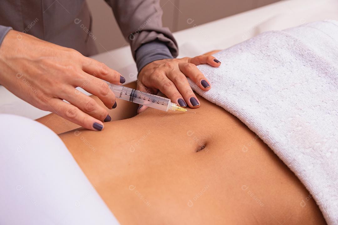 Injeção cosmética no salão spa. Esteticista faz injeção na barriga do paciente. o conceito de rejuvenescimento.