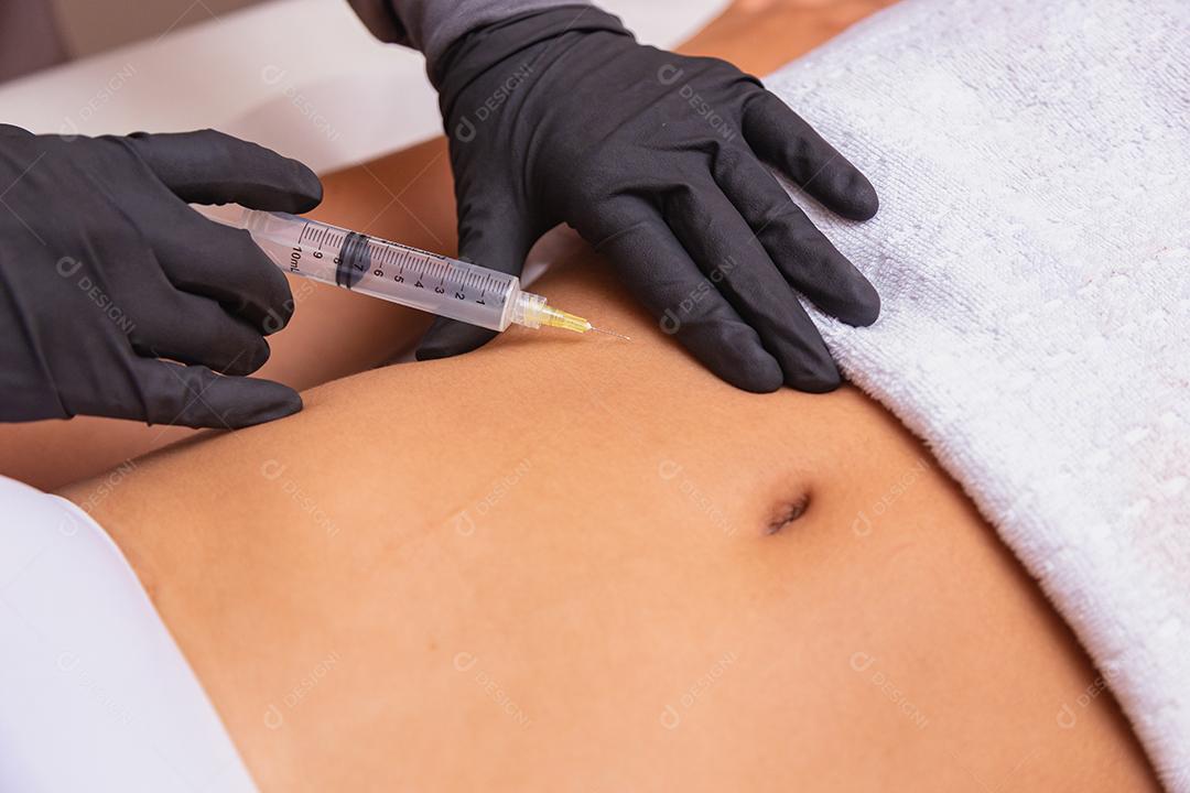 Injeção cosmética no salão spa. Esteticista faz injeção na barriga do paciente. o conceito de rejuvenescimento.