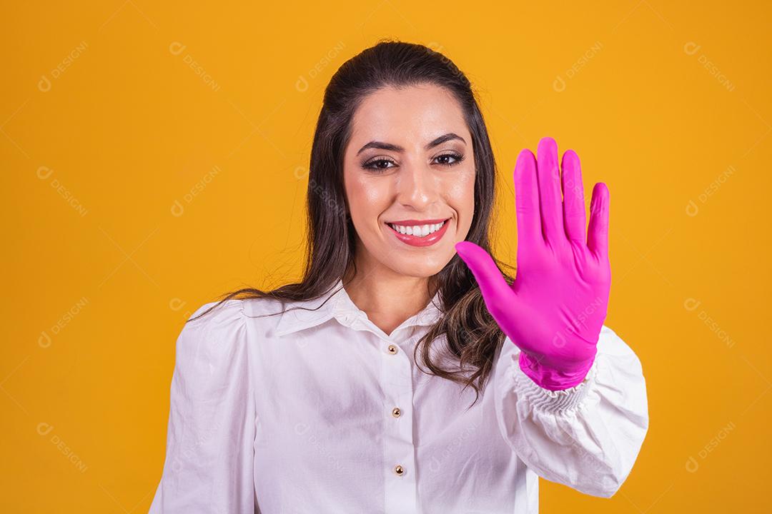 jovem morena com luva rosa, mostrando a palma da mão