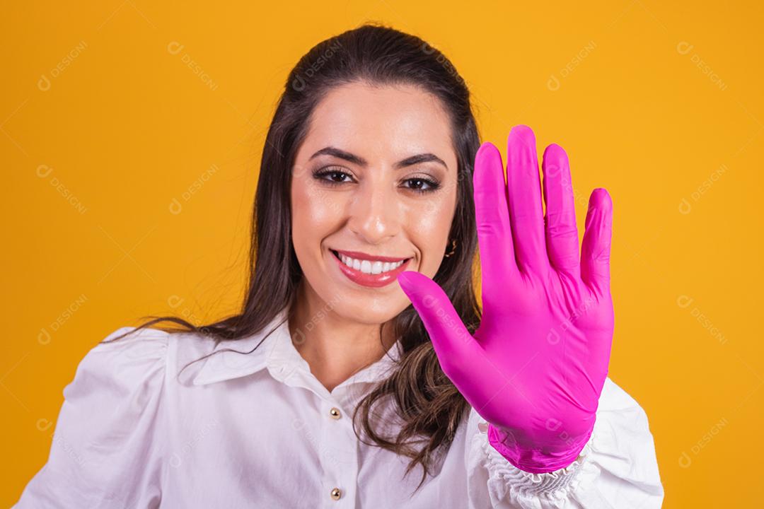 jovem morena com luva rosa, mostrando a palma da mão