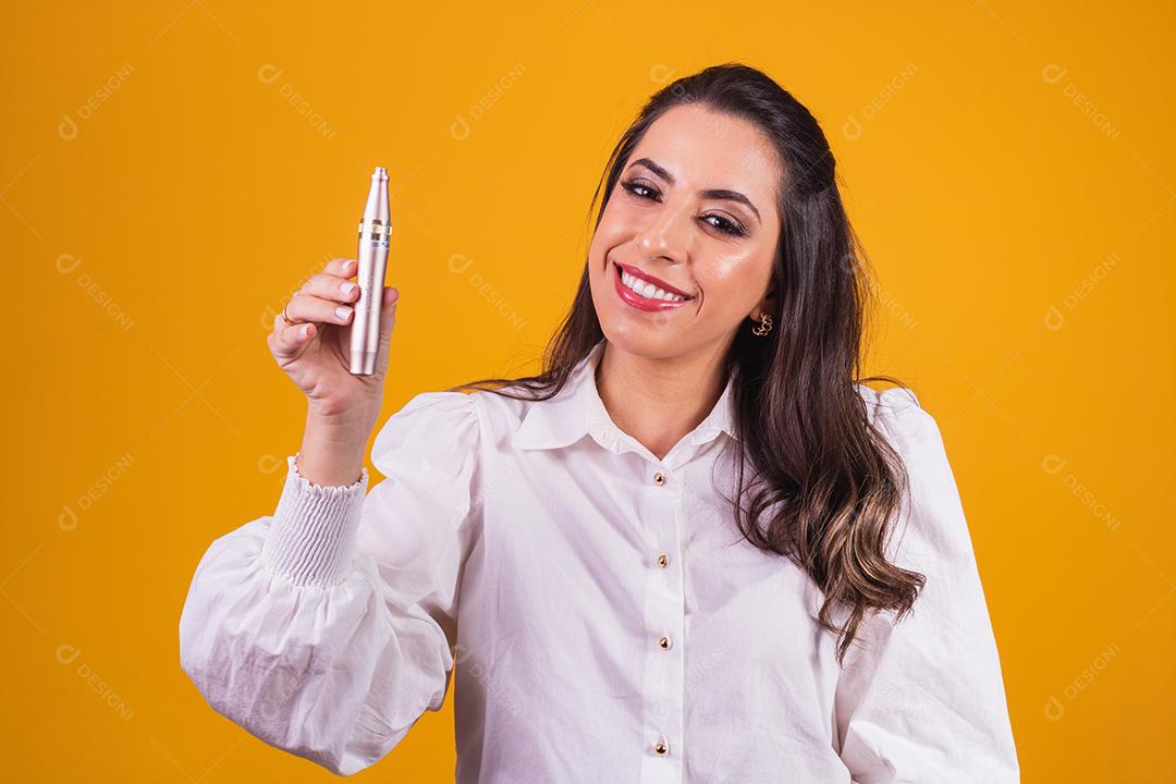 Enfermeira e esteticista segurando um dermapen para hidratação labial em fundo amarelo.