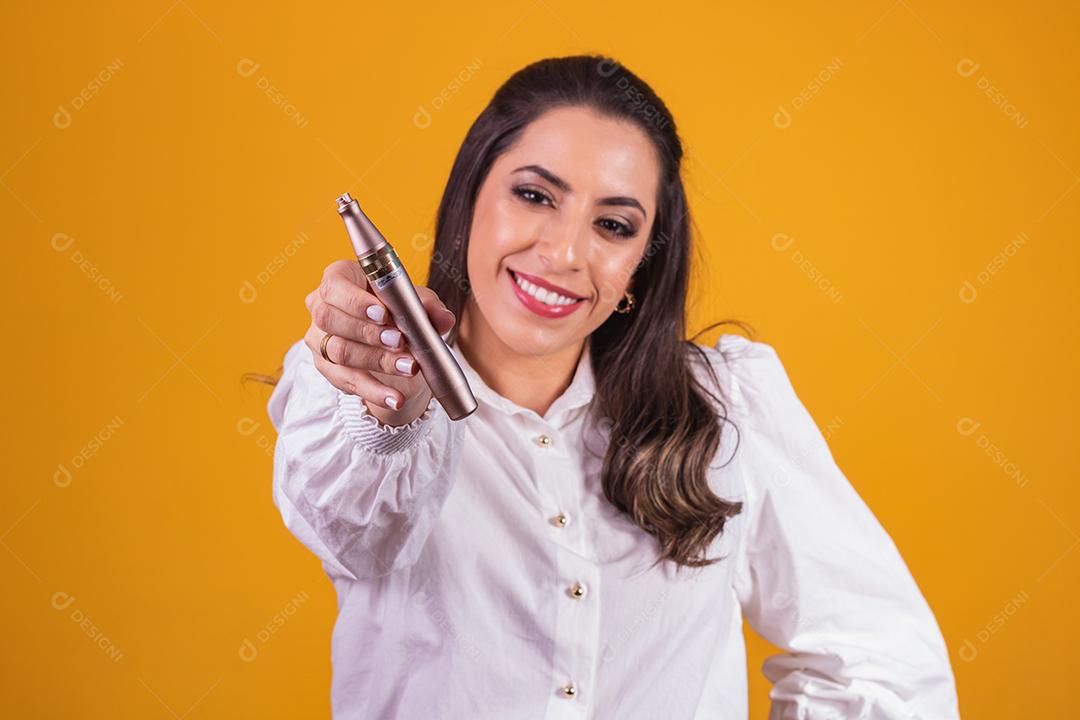 Enfermeira e esteticista segurando um dermapen para hidratação labial em fundo amarelo.